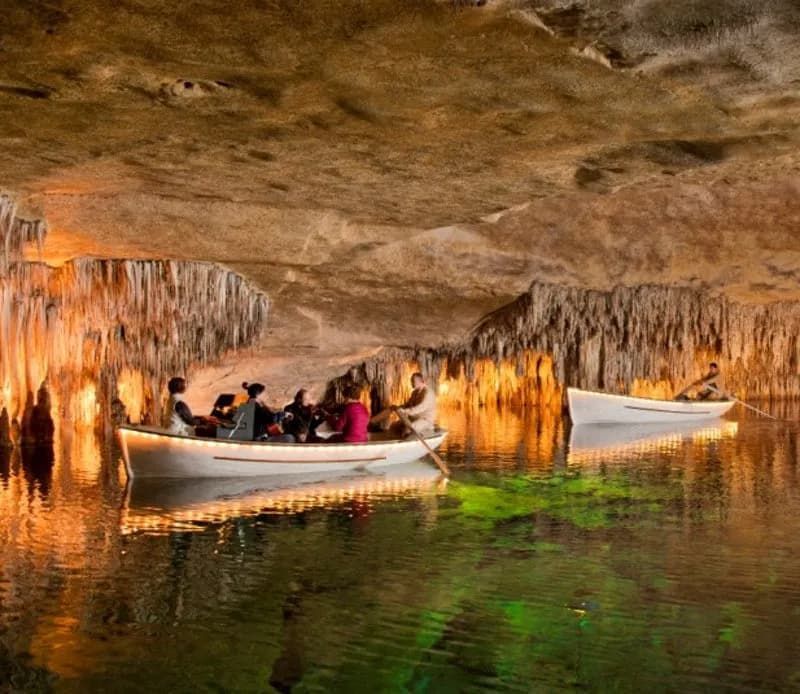 A group of people are in a boat in a cave.