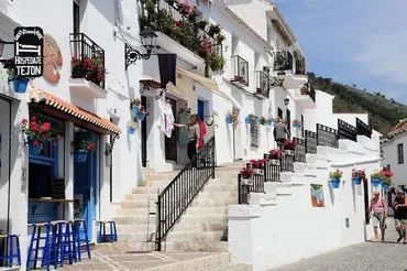 A white building with a sign that says restaurante tejon on it in Mijas