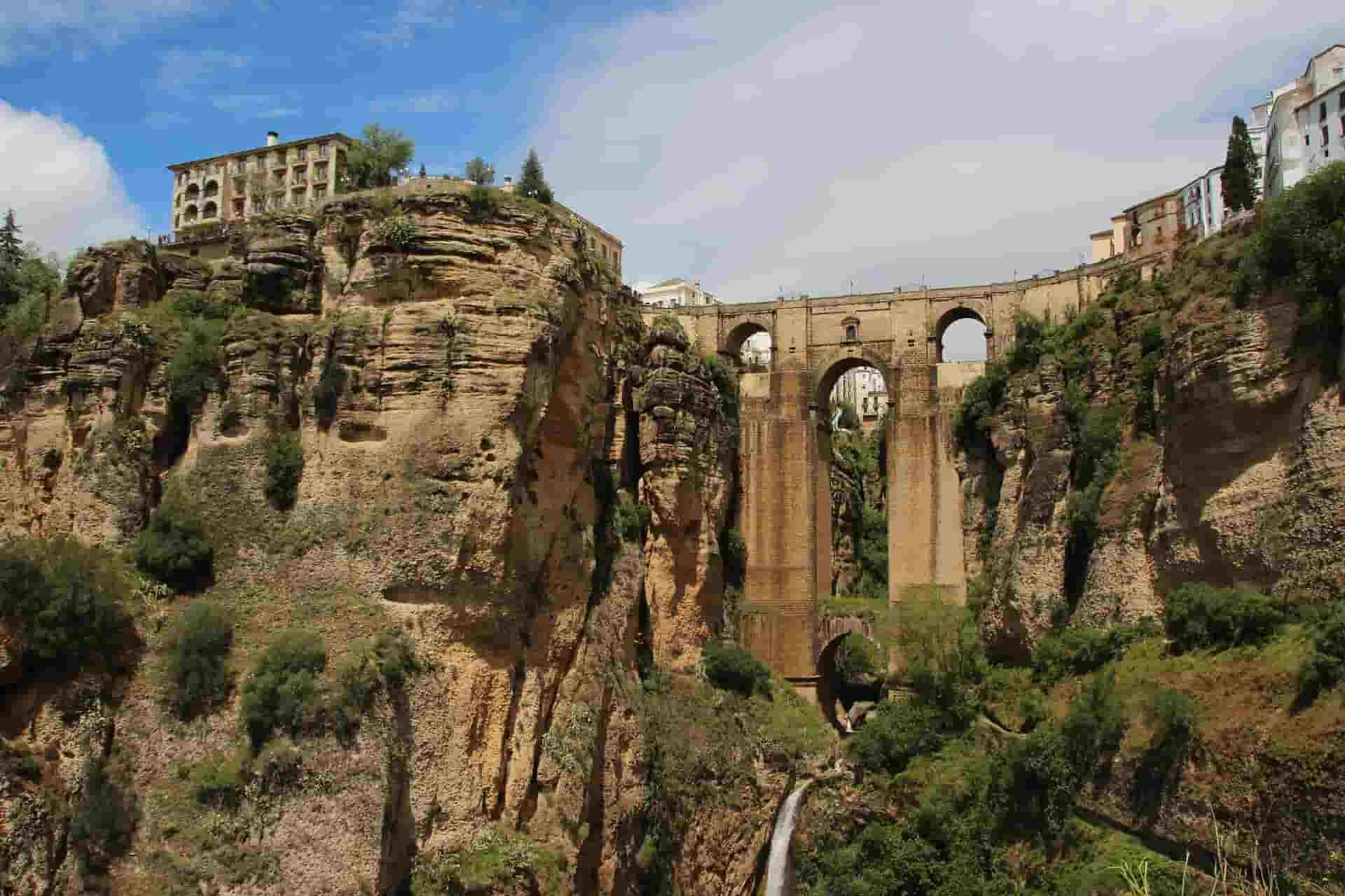 A bridge in the middle of a canyon in Ronda between two cliffs.