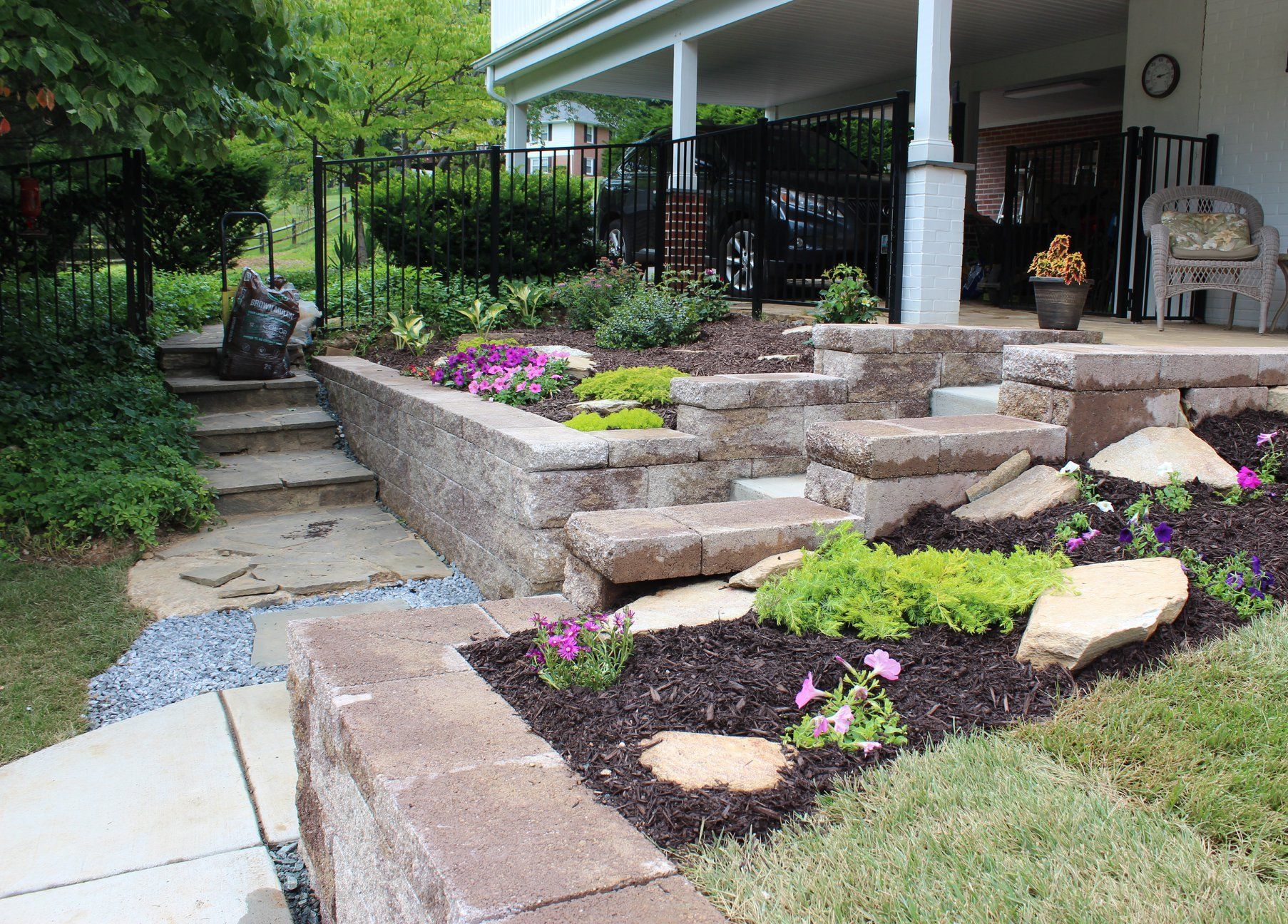 A balcony with a brick style concrete with flowers