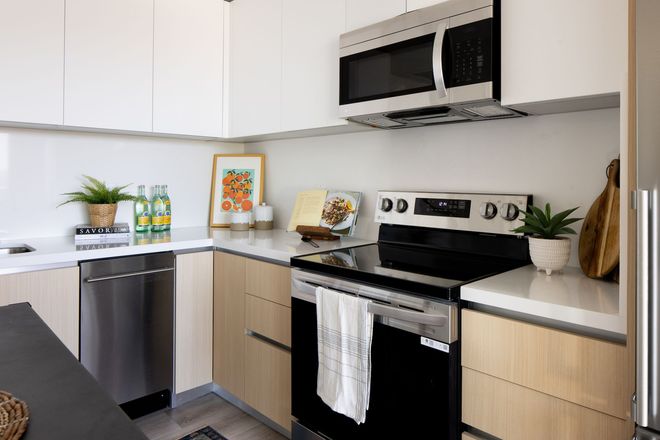 A kitchen with a stove , microwave , dishwasher and refrigerator.