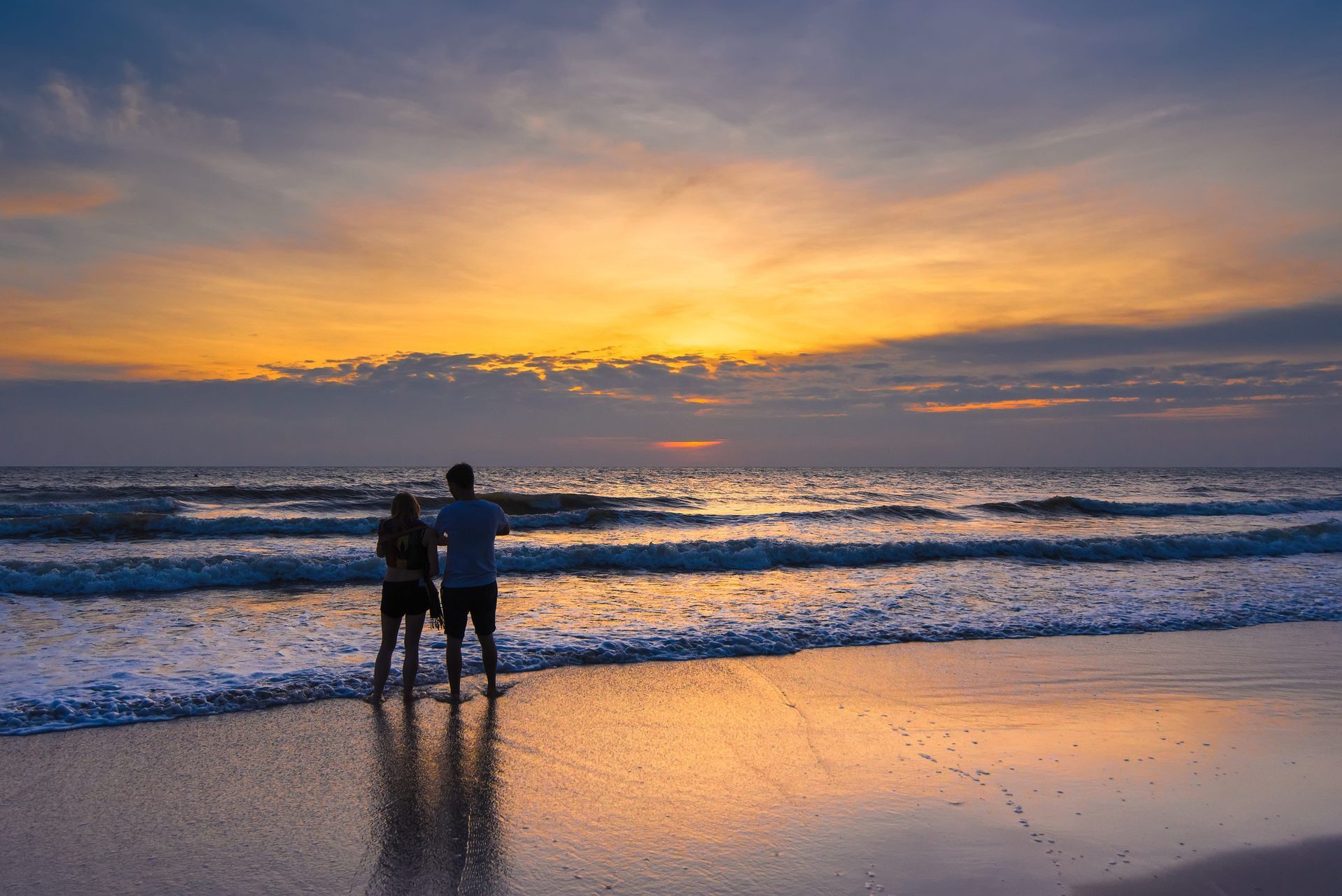 Couple watching the sunrise while on a milestone vacation planned by the experts at Travel Haus.