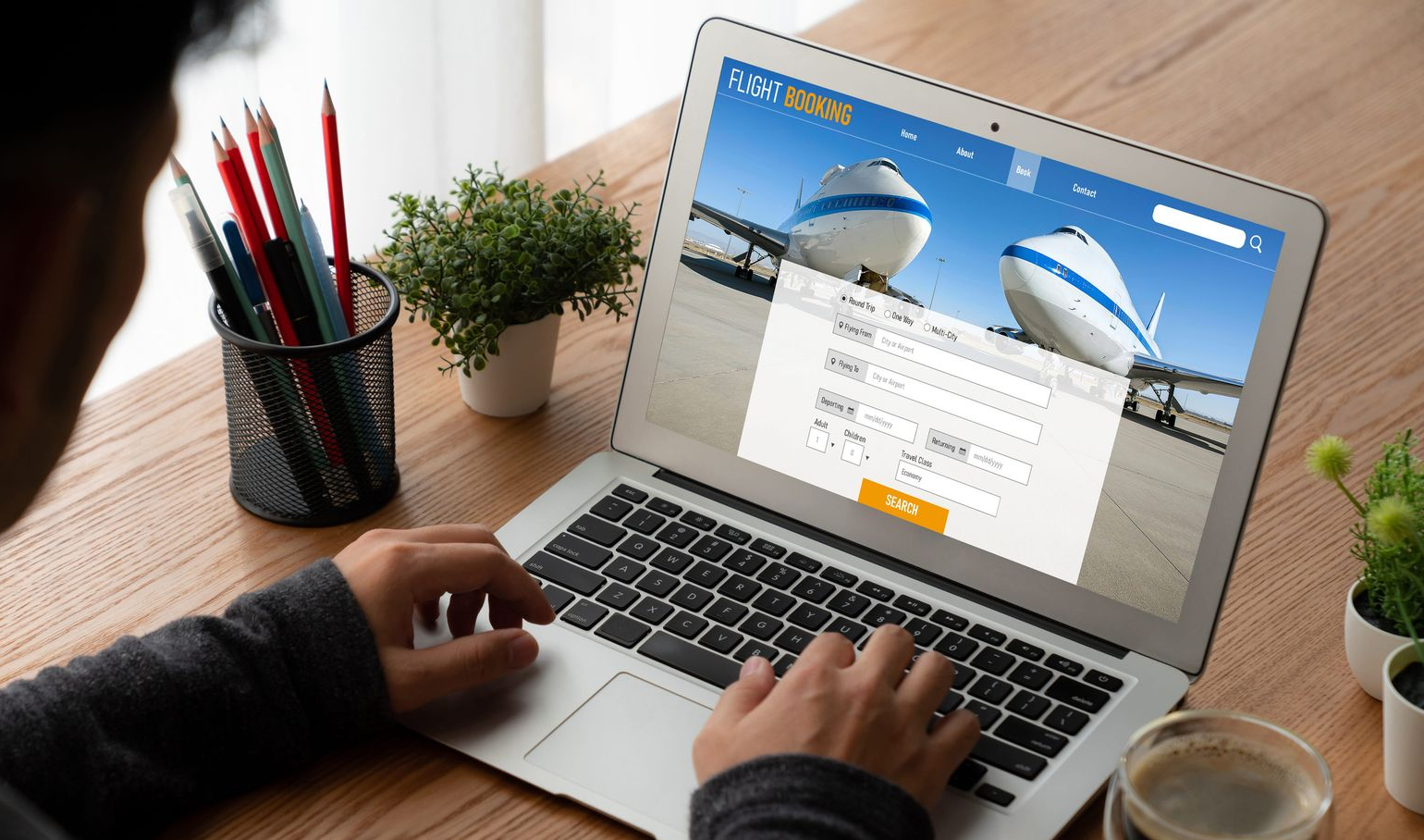 Person searching for flights to book on laptop.