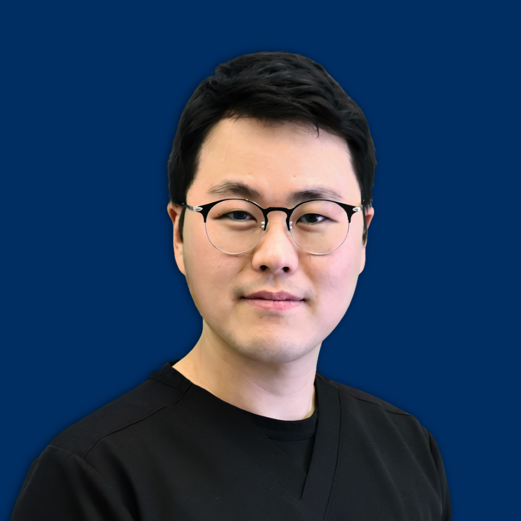 Portrait of a man with glasses in a black shirt against a solid blue background