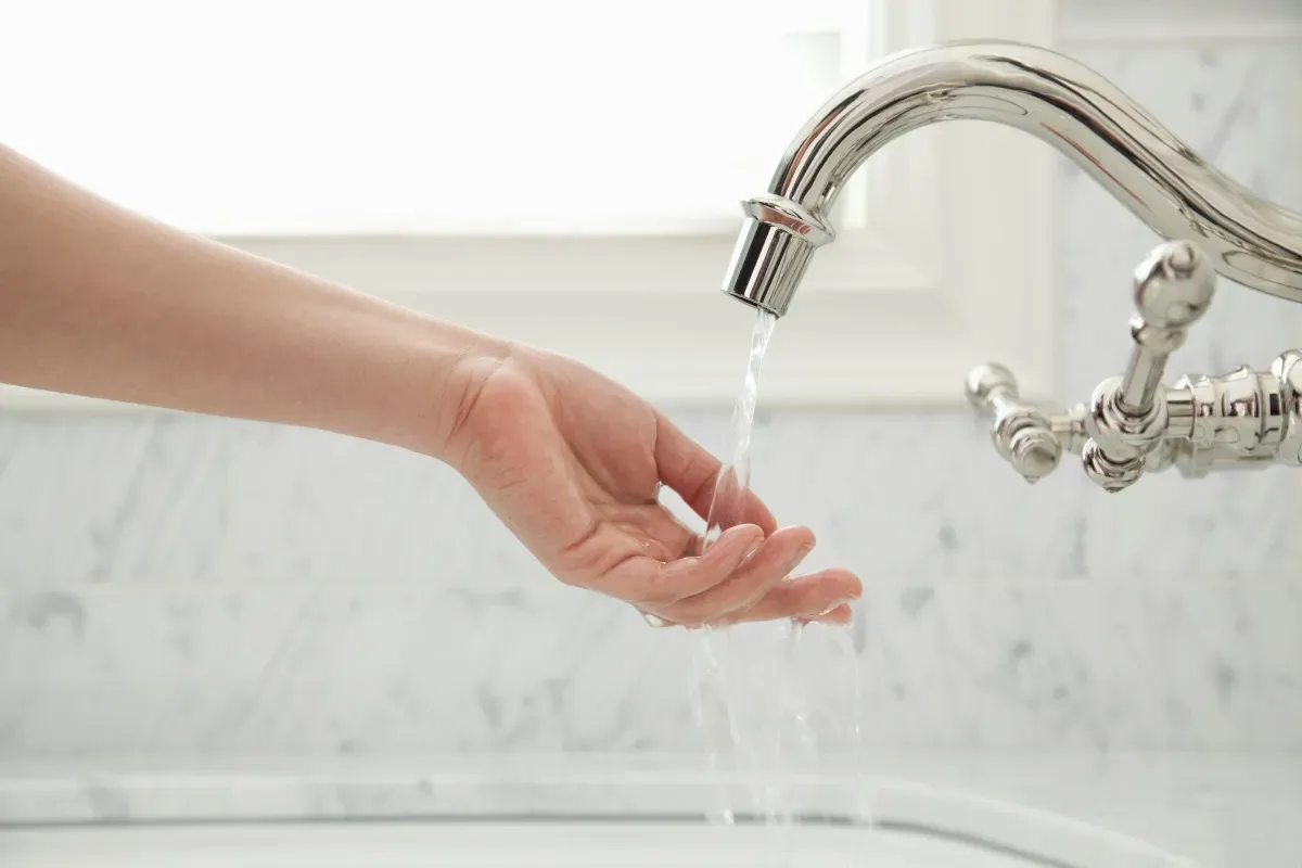 A woman is washing her hands in a bathroom sink. A woman is washing her hands in a bathroom sink.