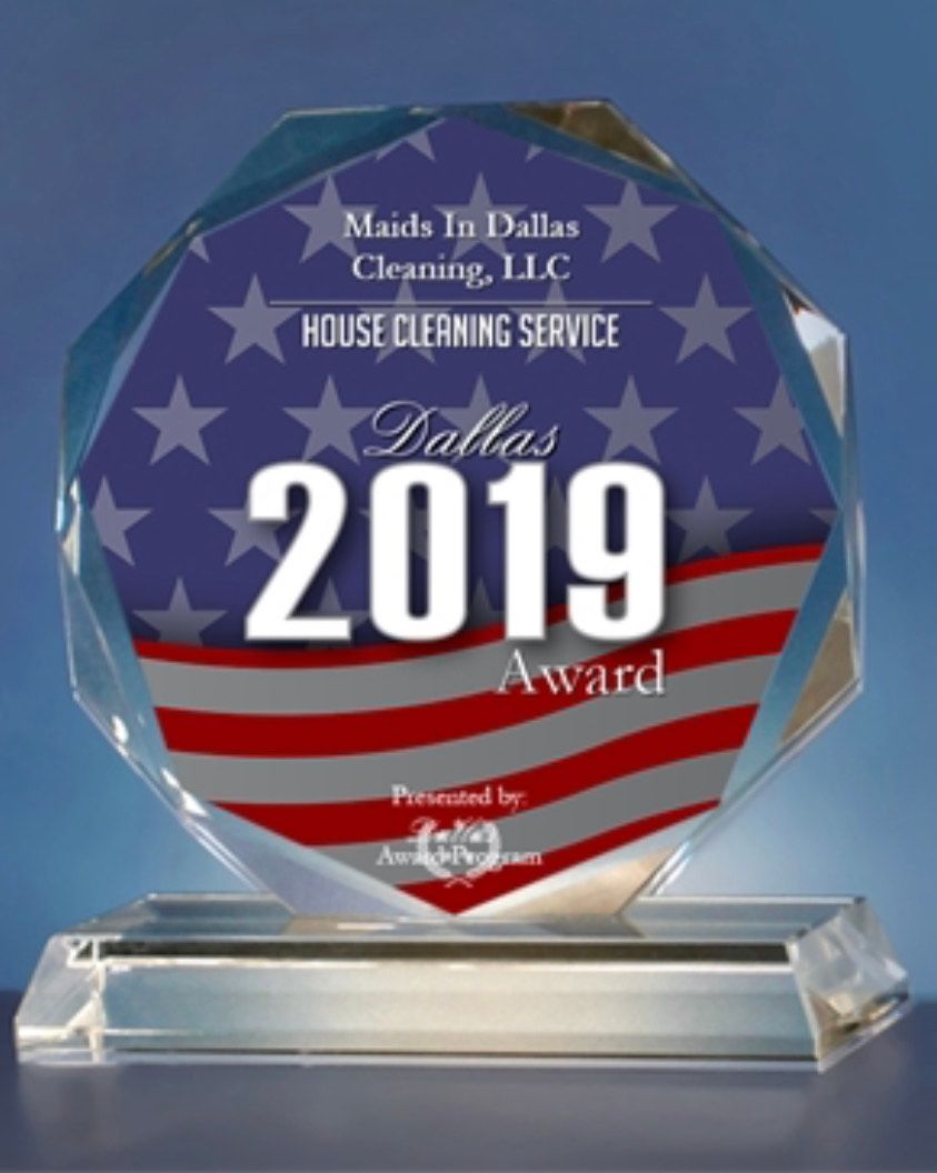A glass award plaque featuring a US flag design, honoring Maids To Dallas Cleaning LLC for a 2019 house cleaning service.