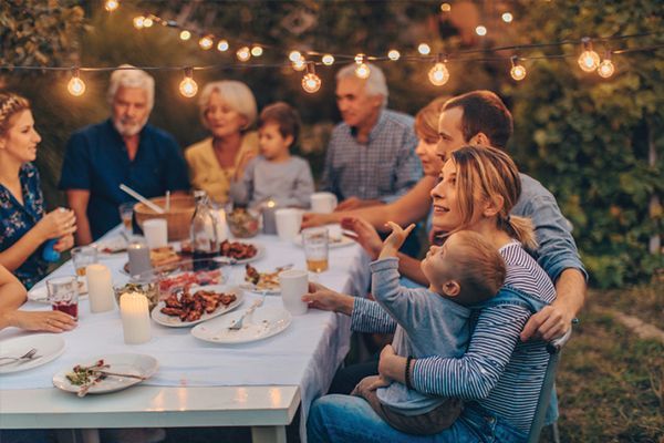 a group of people are sitting around a table eating food .