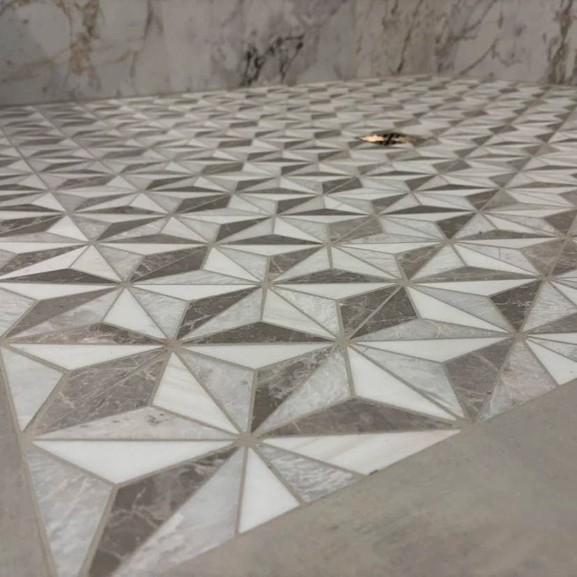 Geometric tile pattern in shades of gray and white.