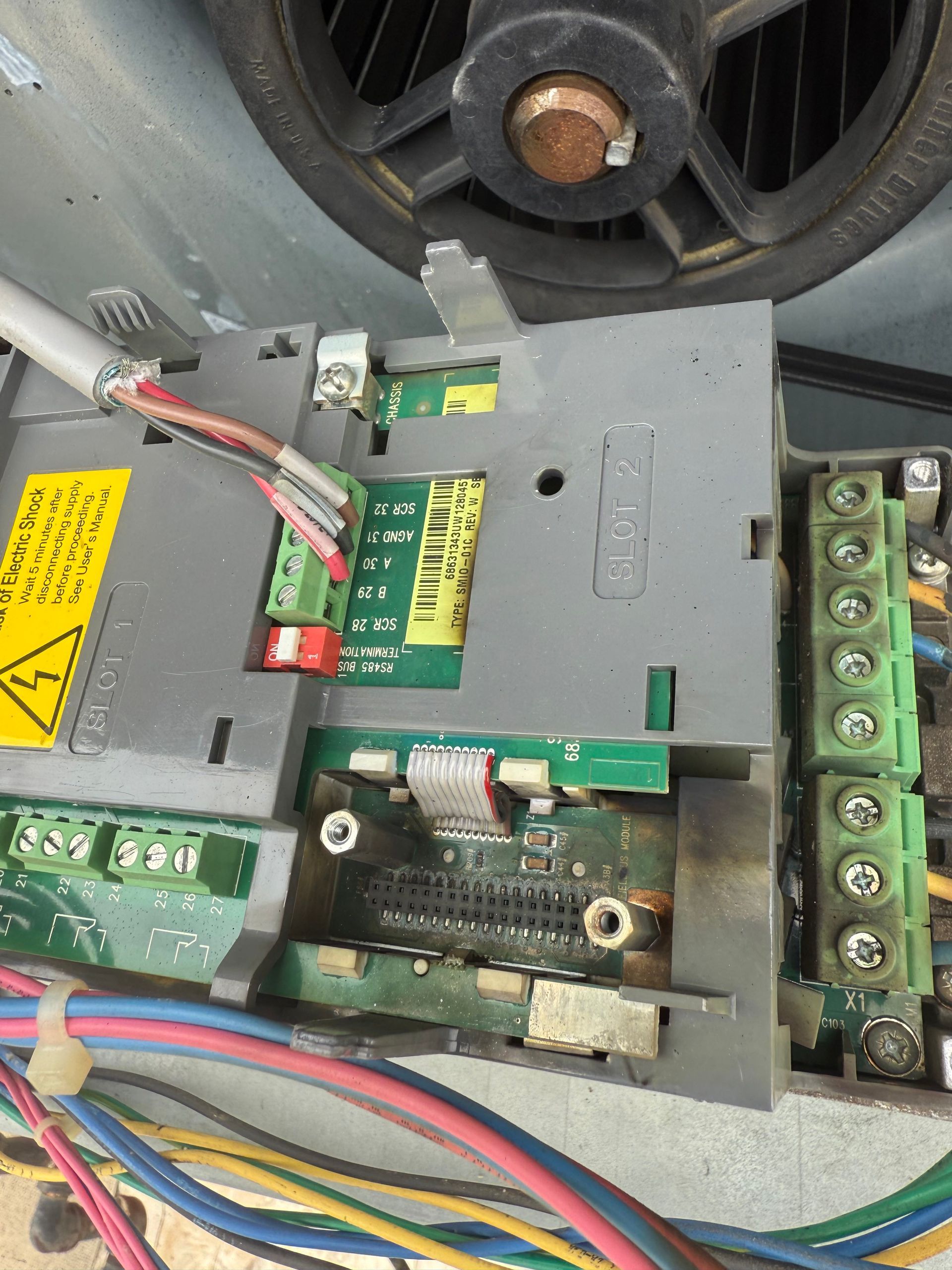 Electronic circuit board with wires and components, some appearing damaged or burned.