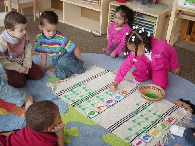 A group of children are playing with numbers on a rug