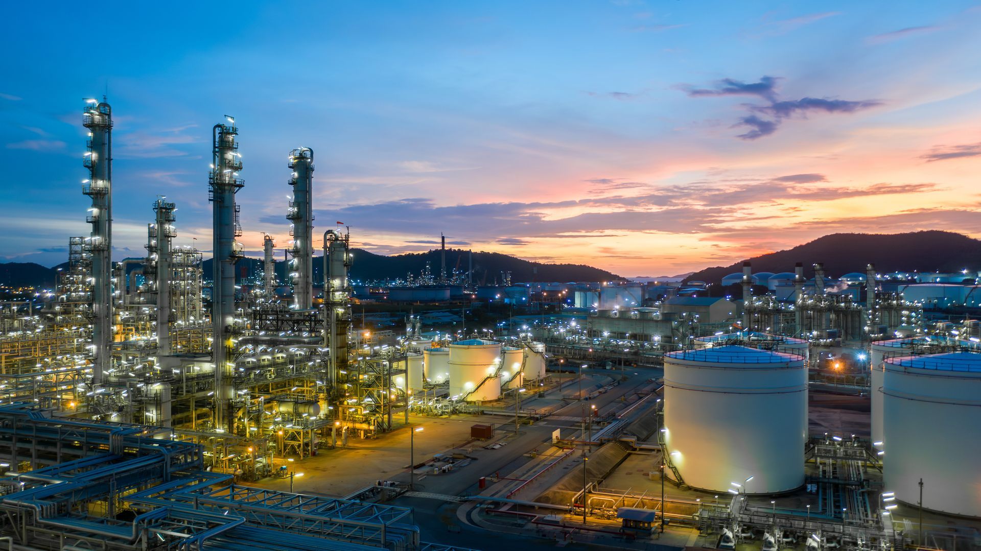 An aerial view of a large oil refinery at sunset.