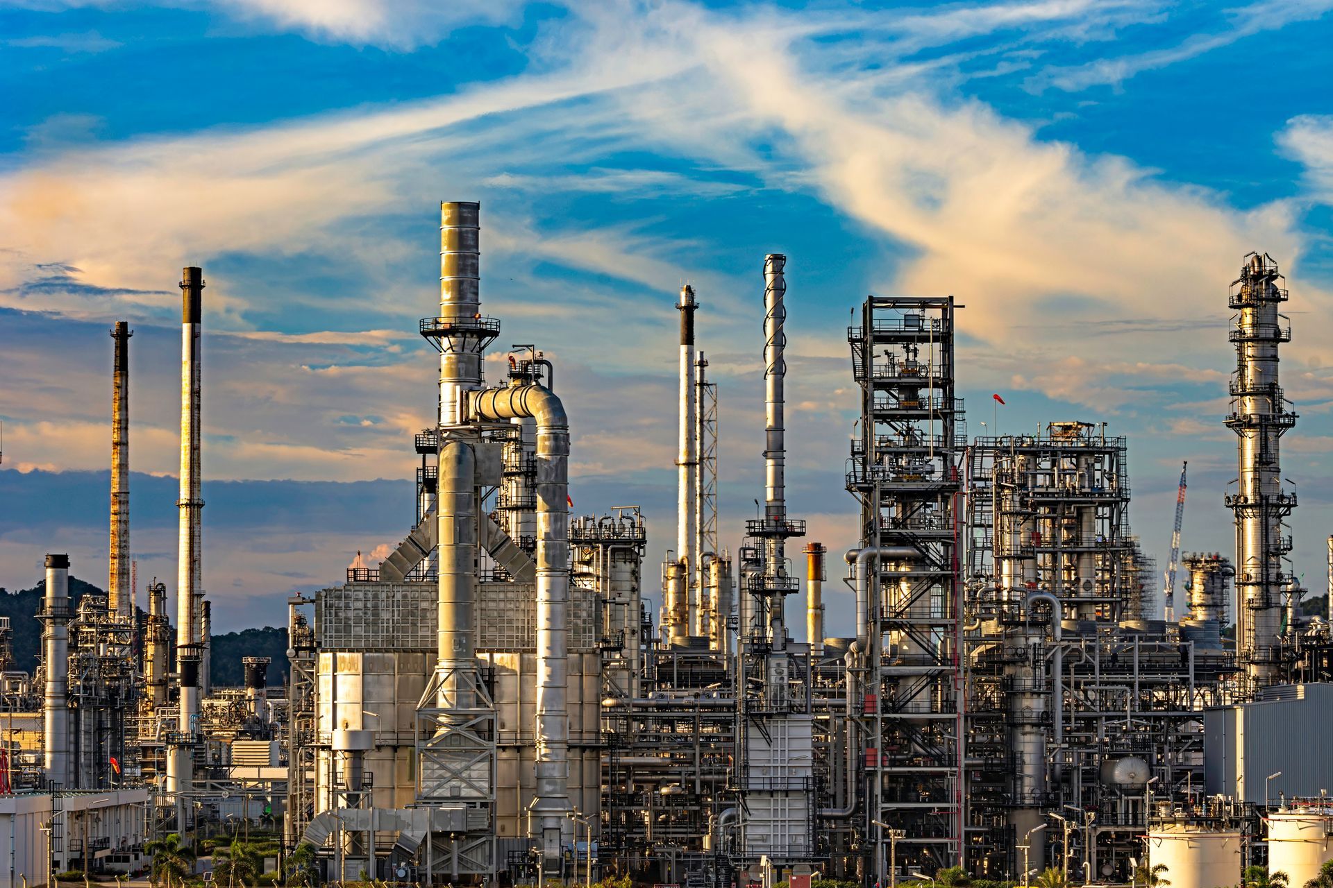 A large oil refinery with a blue sky in the background.
