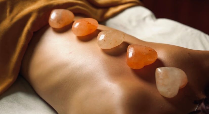 Stones placed along a person’s bare back during a massage or spa treatment