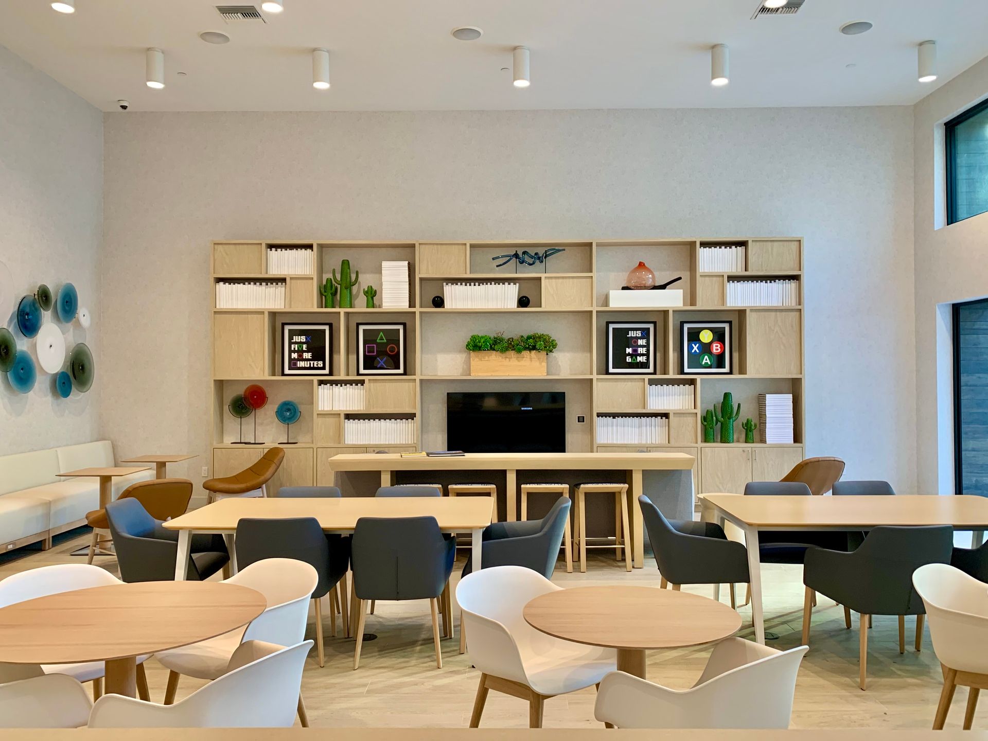 There are many tables and chairs in the room.