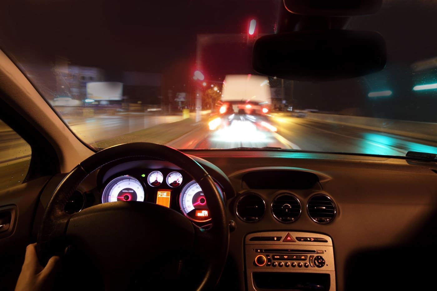 A Man In A Suit Is Driving A Car — Spencer Lawyers In Gosford, NSW