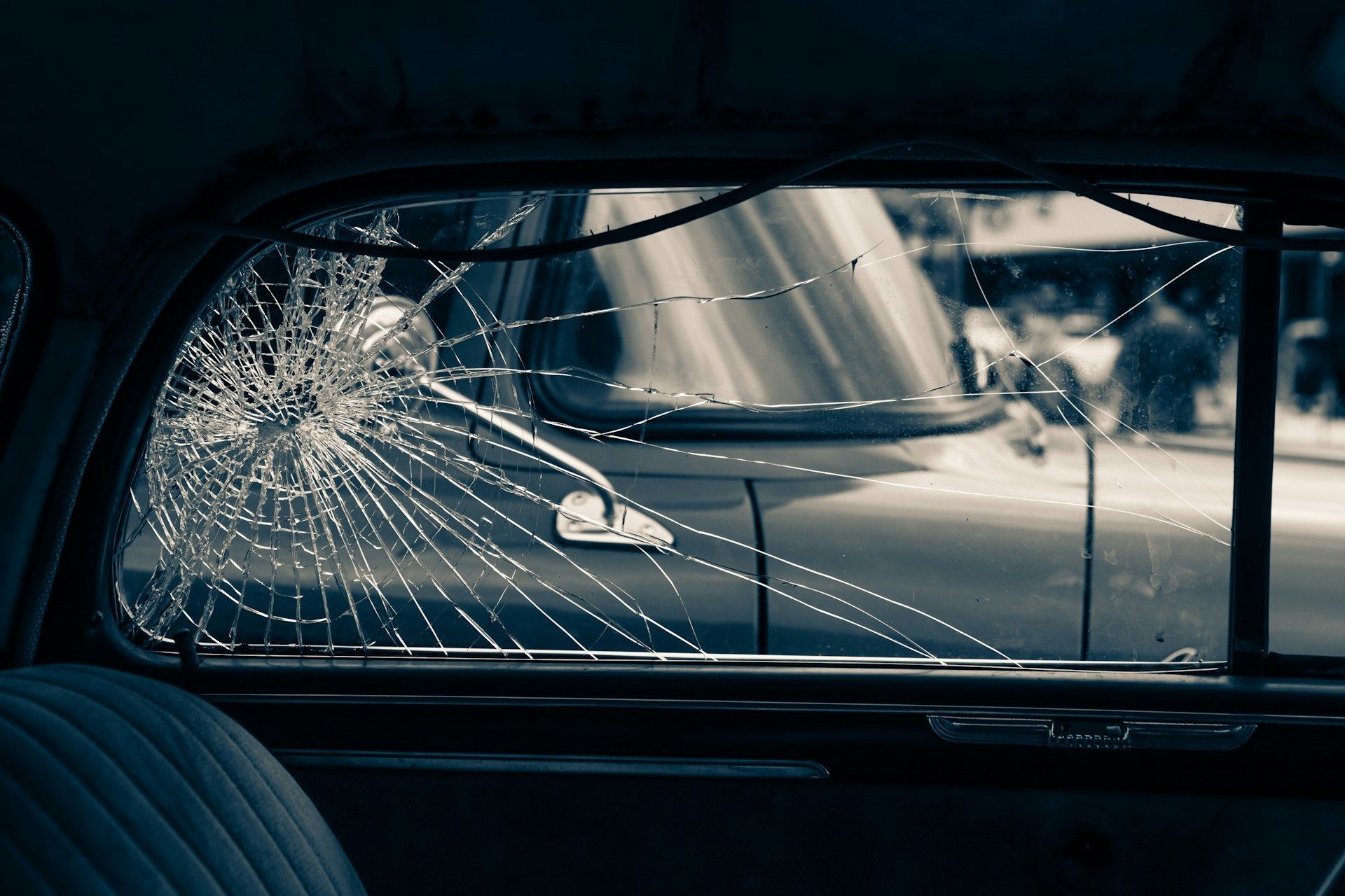 Cracked car window with a view of another car, likely from an accident.