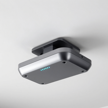 Small silver ceiling-mounted electronic device with blue indicator lights