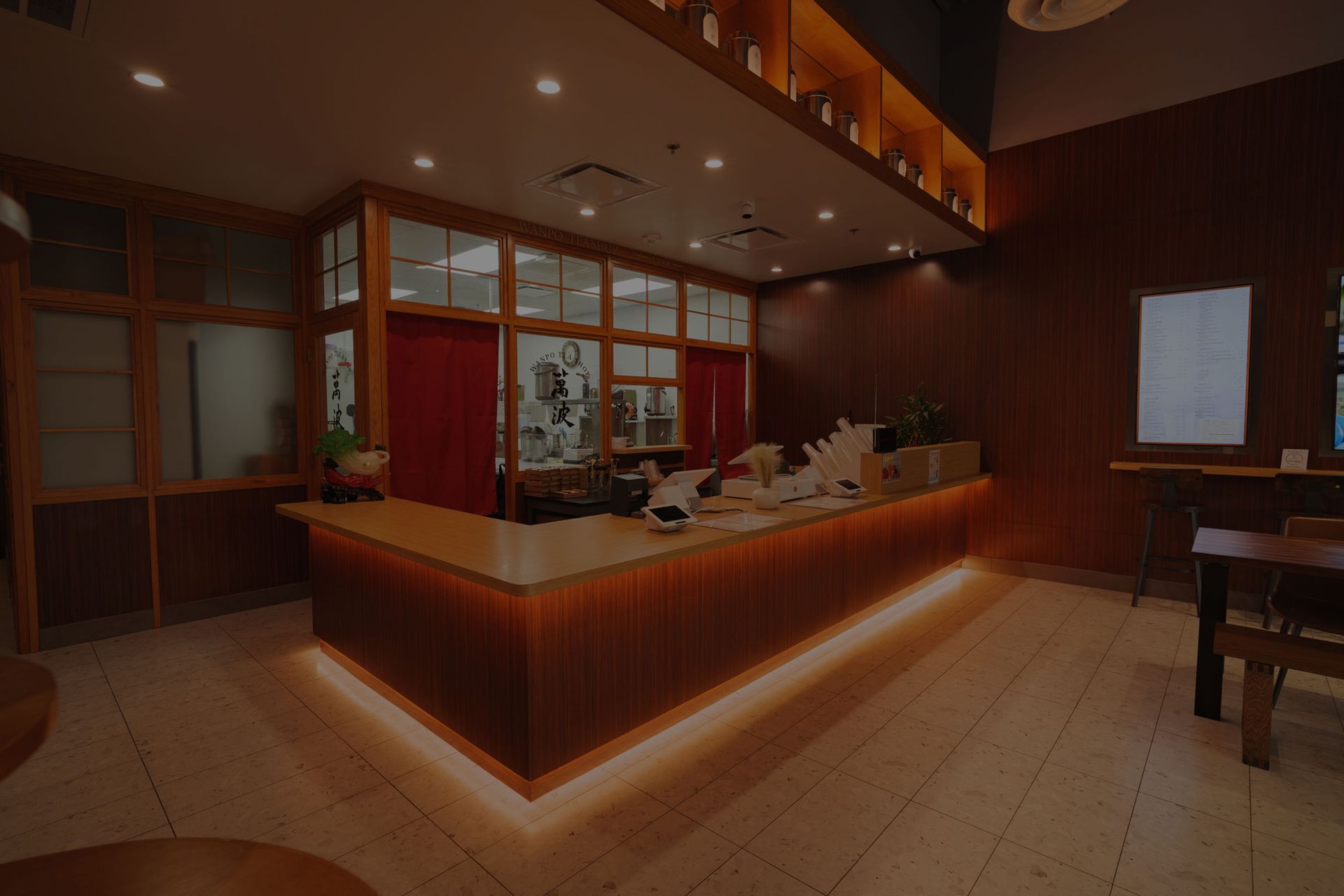 Warmly lit hotel reception desk with wood paneling and tiled floor