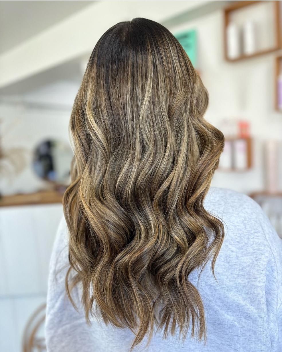 A Woman With Long Blonde Hair Is Standing In A Room — Freedom Hairdressing In Casino, NSW