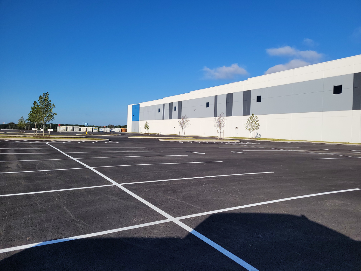 A parking lot with a large building in the background