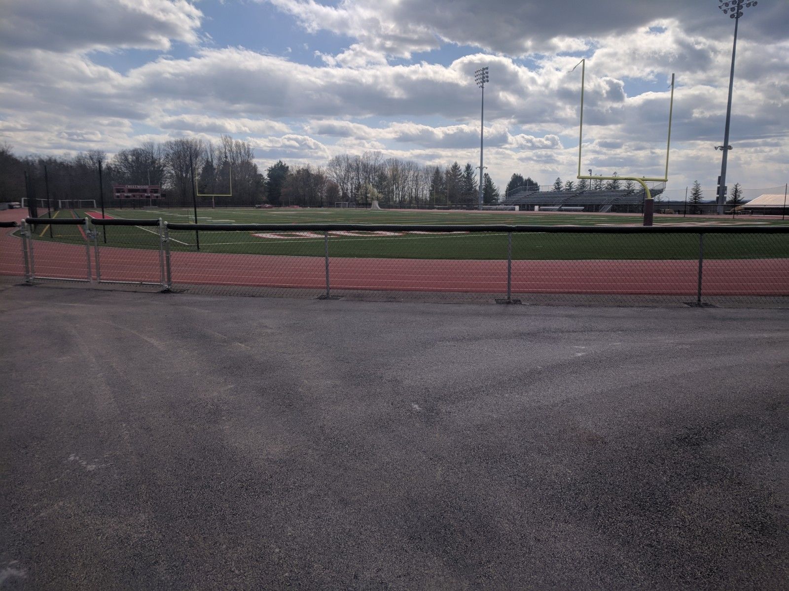 A fence surrounds a football field on a cloudy day
