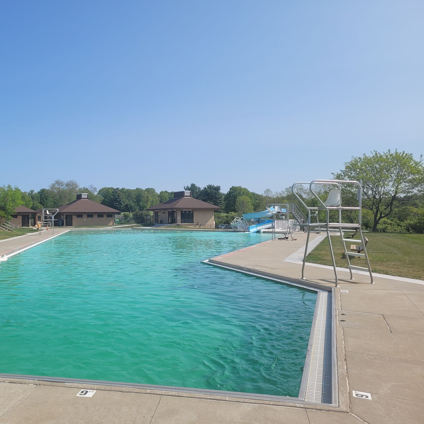 A large swimming pool with a lifeguard tower in the background