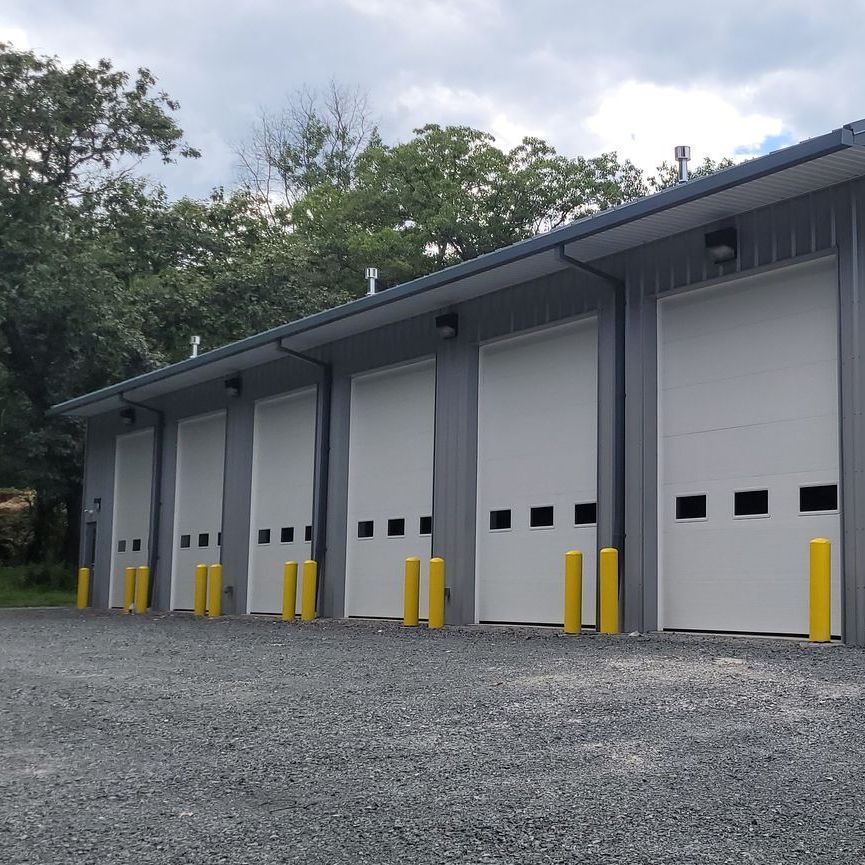 A row of garage doors with yellow poles in front of them