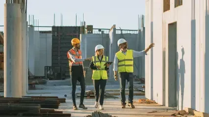 A group of construction workers are walking on a construction site. A group of construction workers are walking on a construction site.