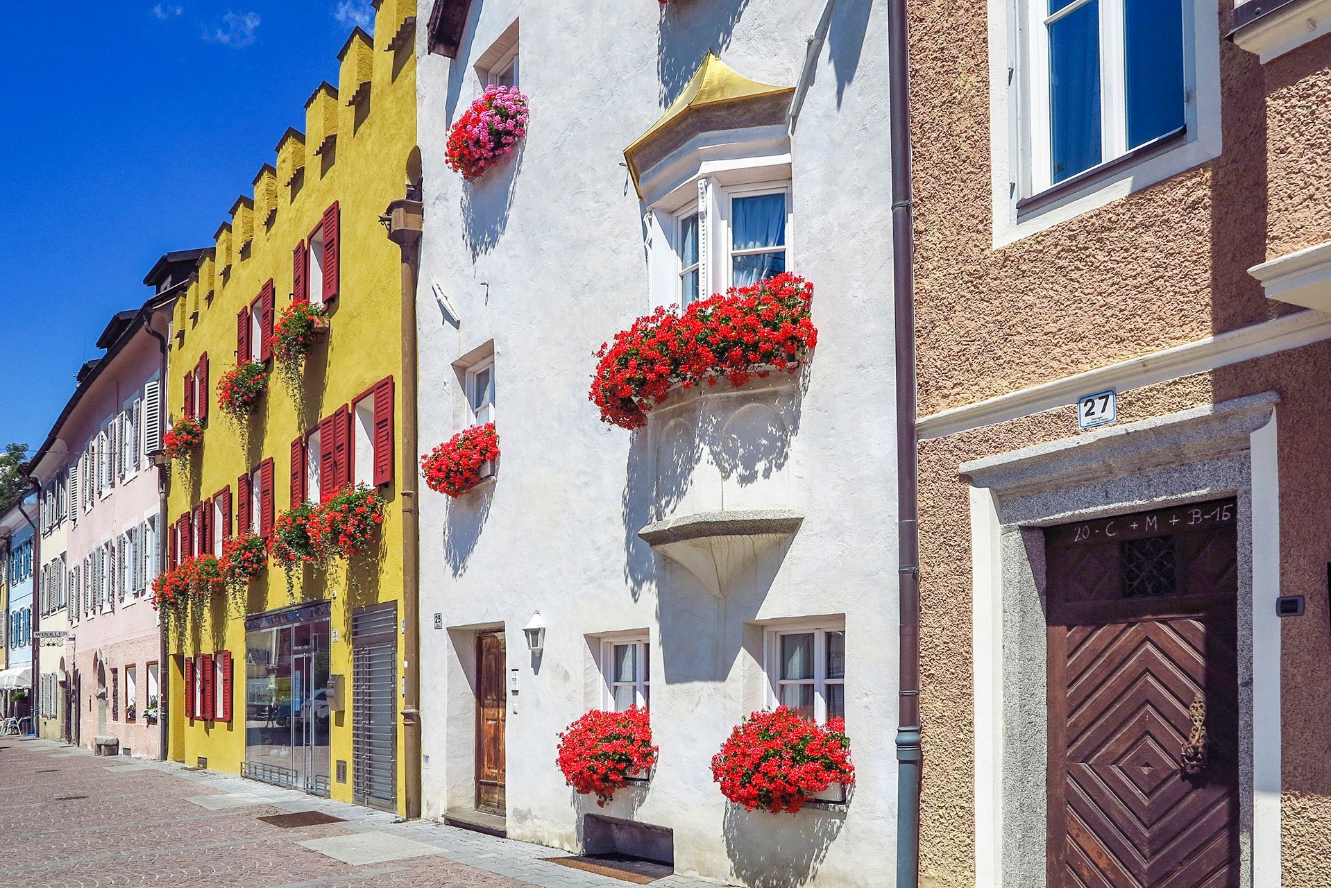 Eine Reihe von Gebäuden mit roten Blumen an den Fenstern