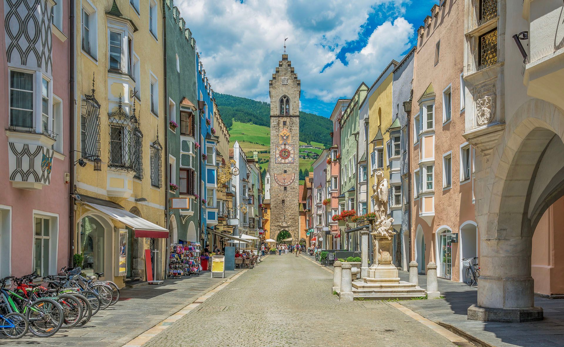 Eine Stadtstraße mit einem Uhrturm in der Mitte.
