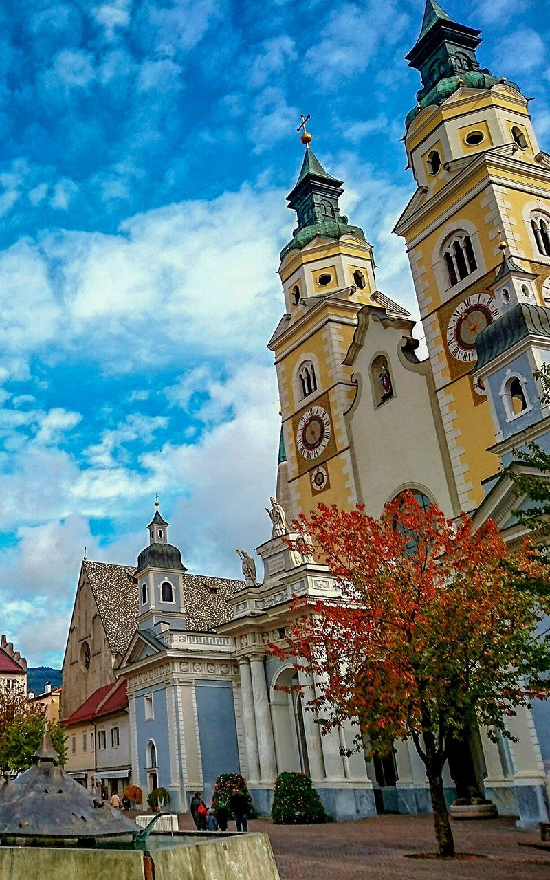 Eine große Kirche mit zwei Uhrtürmen und einem Baum davor