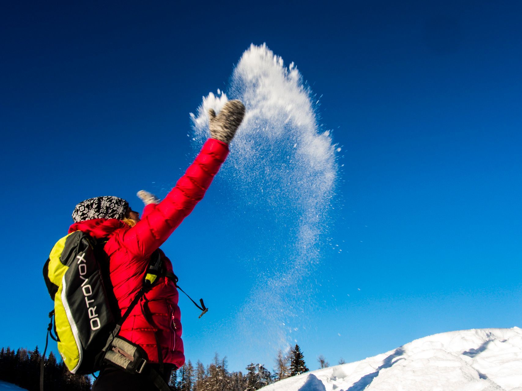 Eine Person wirft Schnee in die Luft.