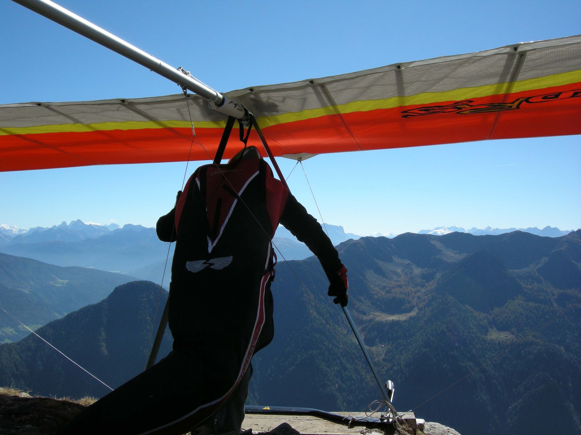 Eine Person fliegt mit einem Fallschirm über eine Bergkette