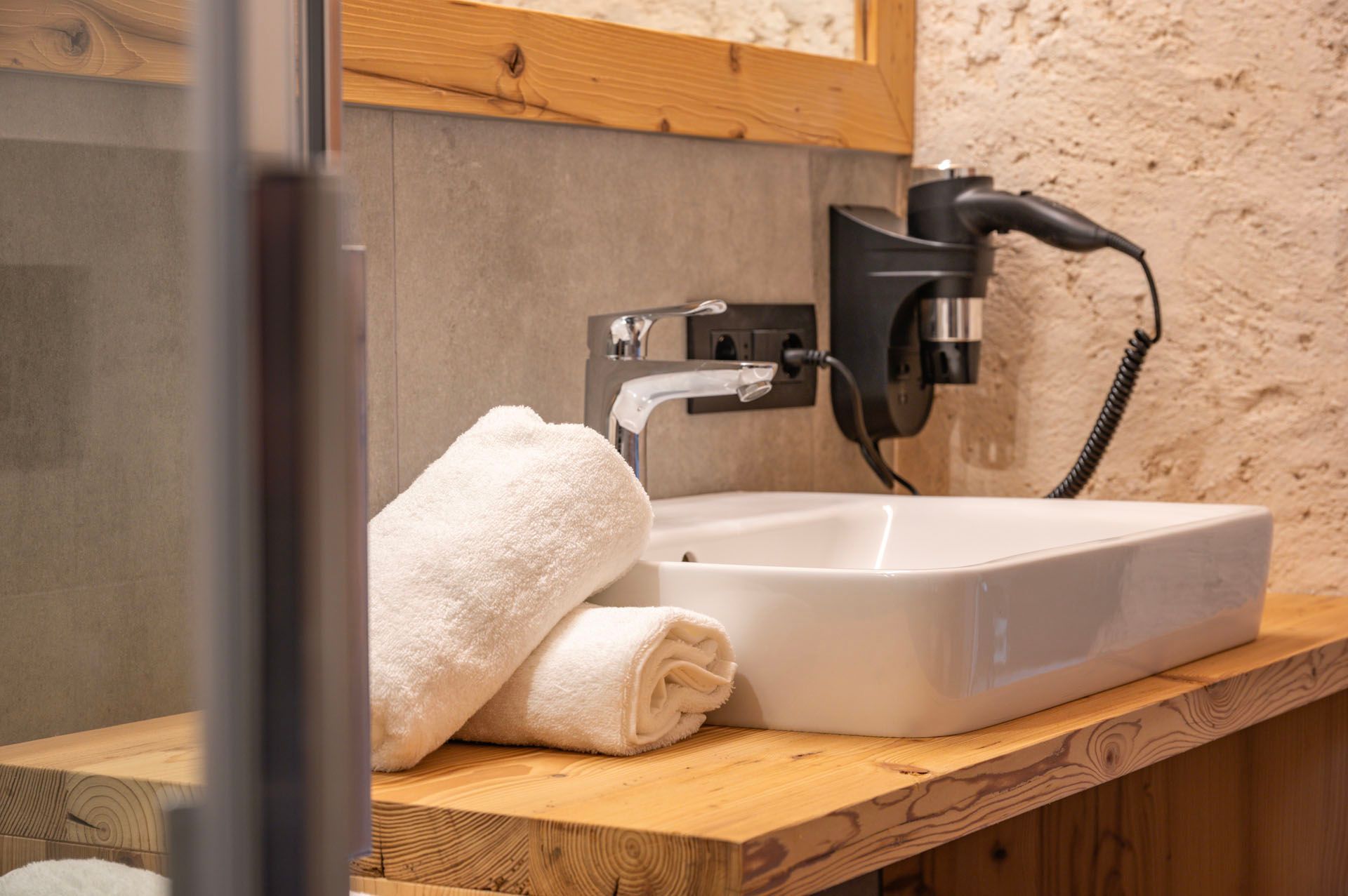 Ein Badezimmer mit Waschbecken, Handtüchern und Haartrockner.
