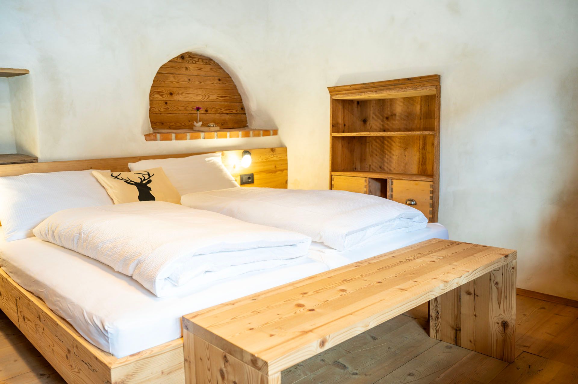 Ein Schlafzimmer mit zwei Betten und einer Holzbank.