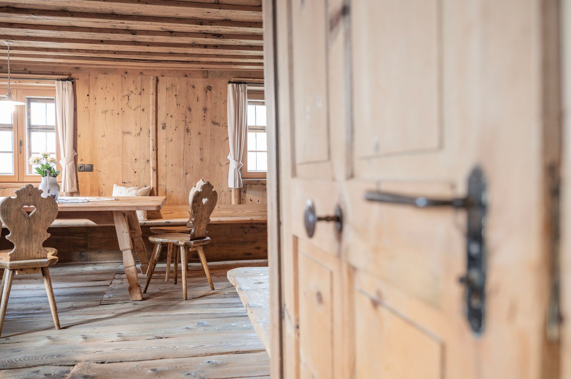 Ein Holzraum mit einem Tisch und Stühlen darin.