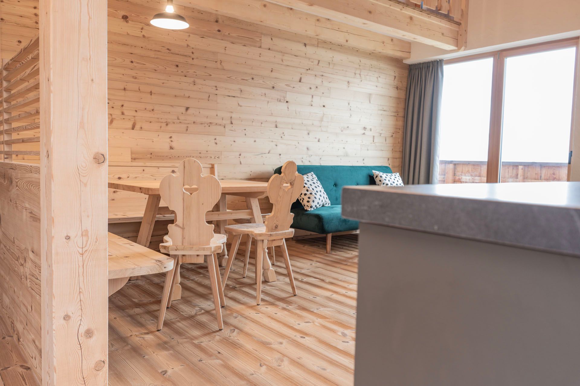 Ein Wohnzimmer mit einem Holztisch und Stühlen und einer blauen Couch.