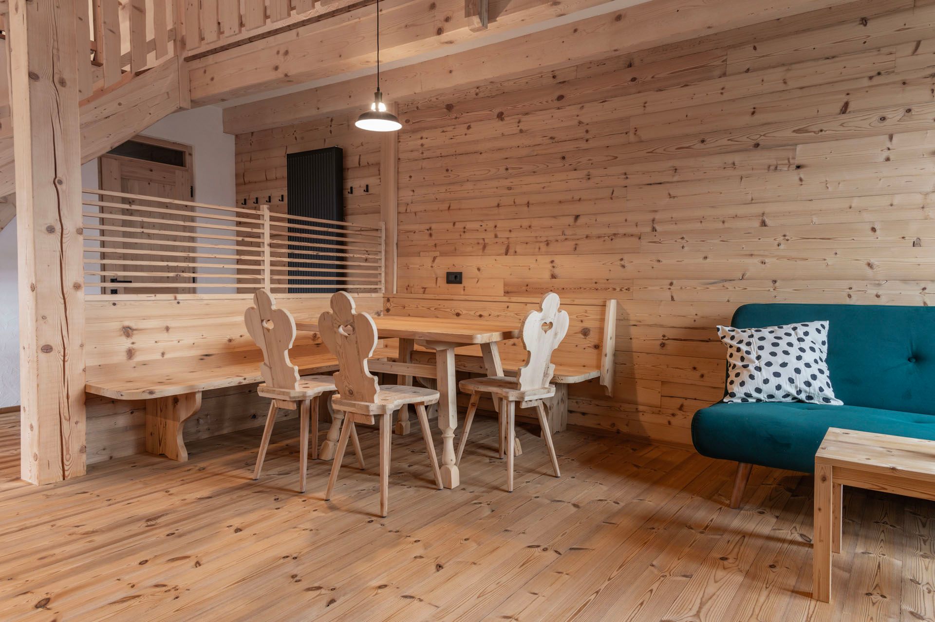 Ein Wohnzimmer mit einer blauen Couch und einem Holztisch mit Stühlen.