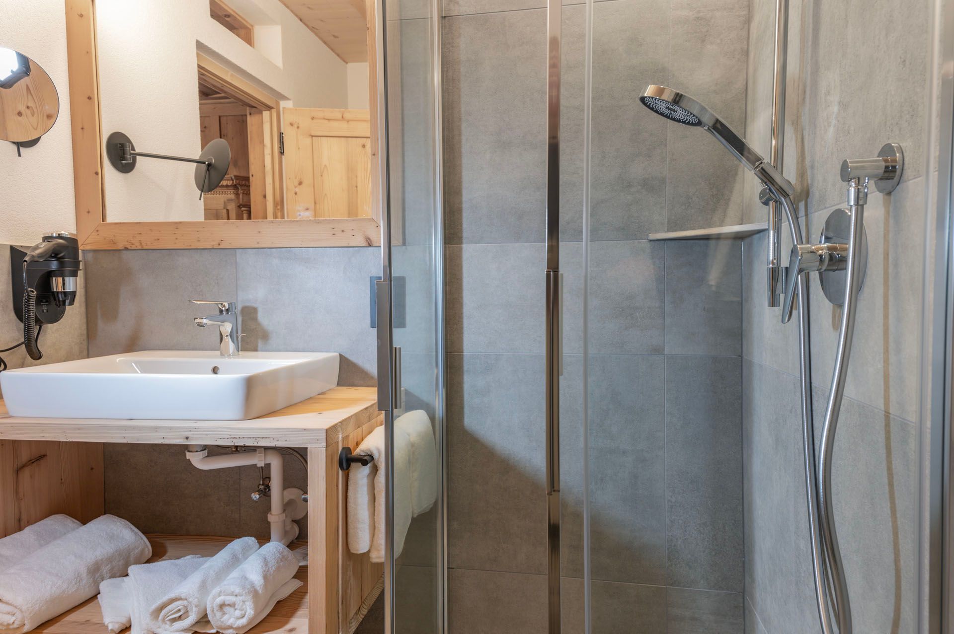 Ein Badezimmer mit Waschbecken, Dusche und Spiegel.
