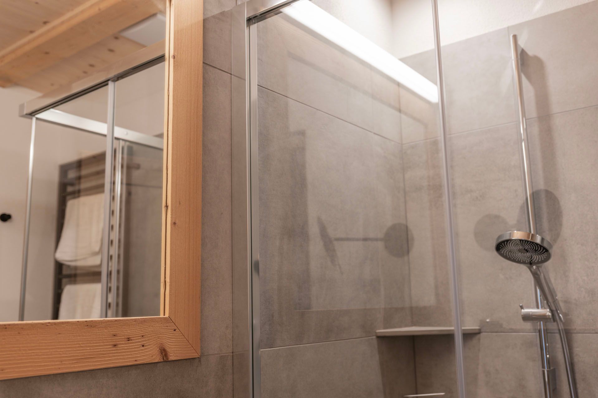 Ein Badezimmer mit Dusche, Spiegel und Handtuchhalter