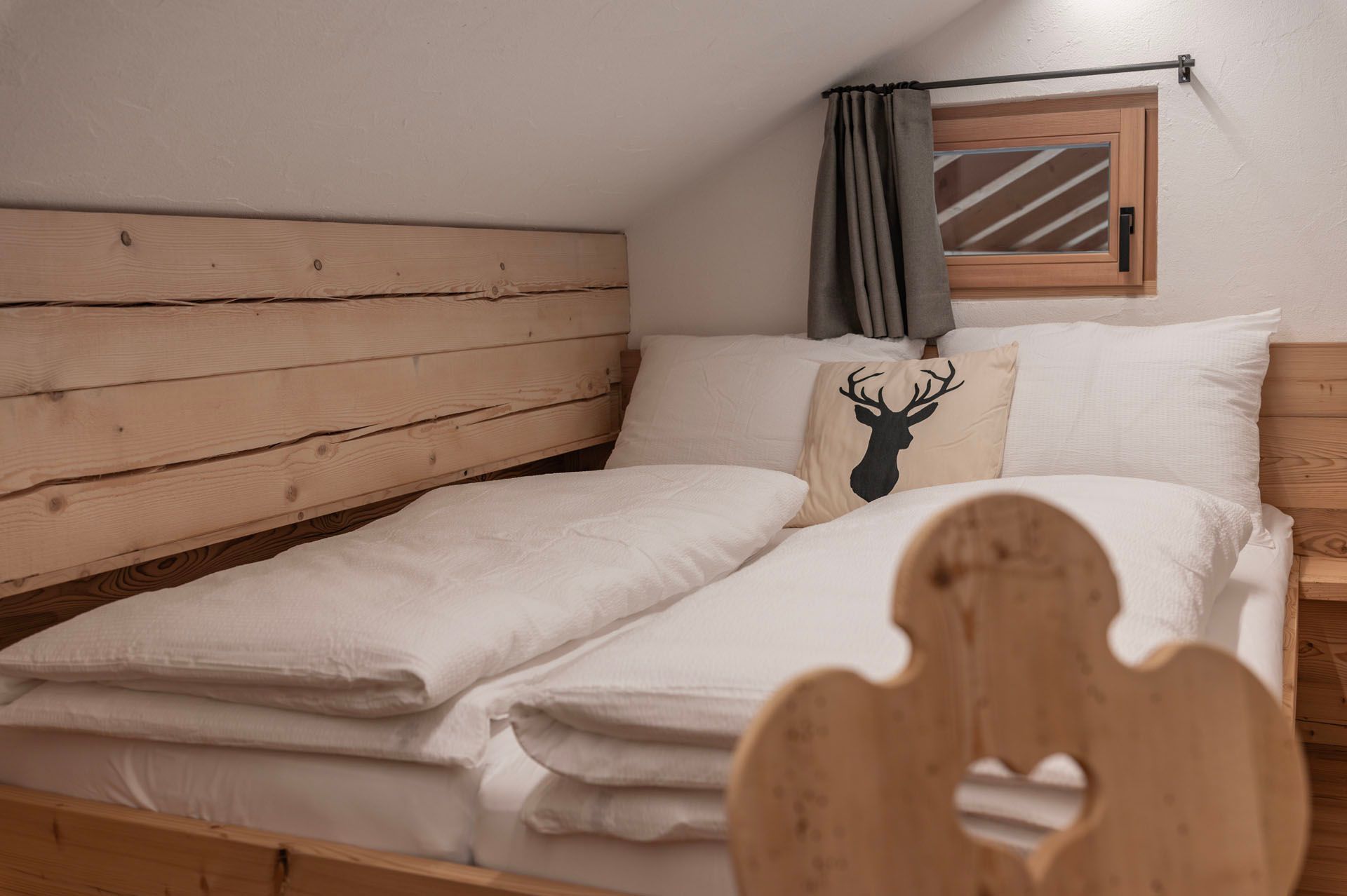Ein Schlafzimmer mit zwei Betten, einem hölzernen Kopfteil und einem Fenster.