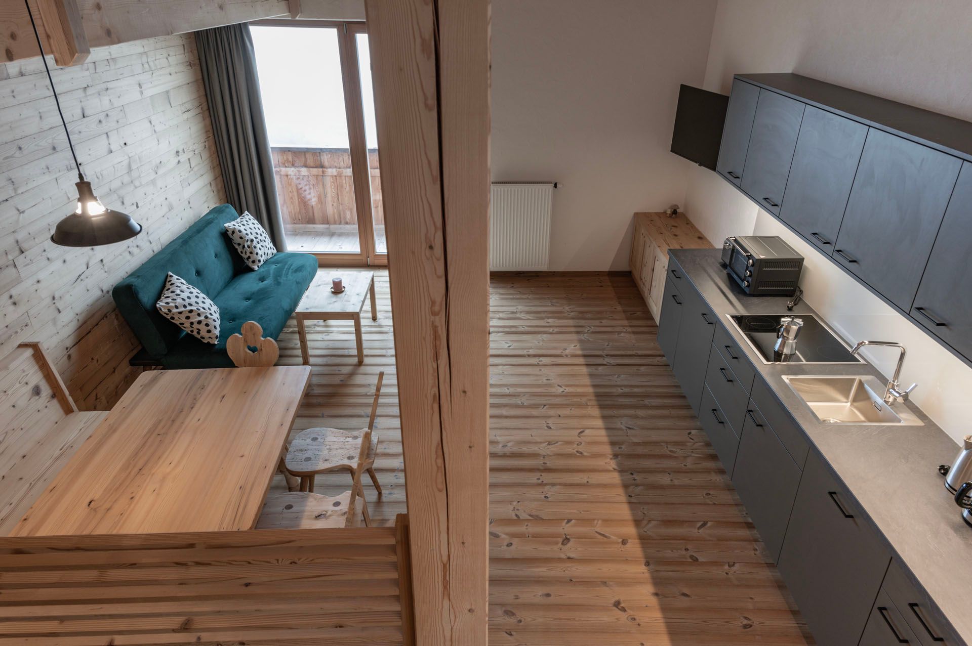 Ein Wohnzimmer mit einer blauen Couch und einer Küche