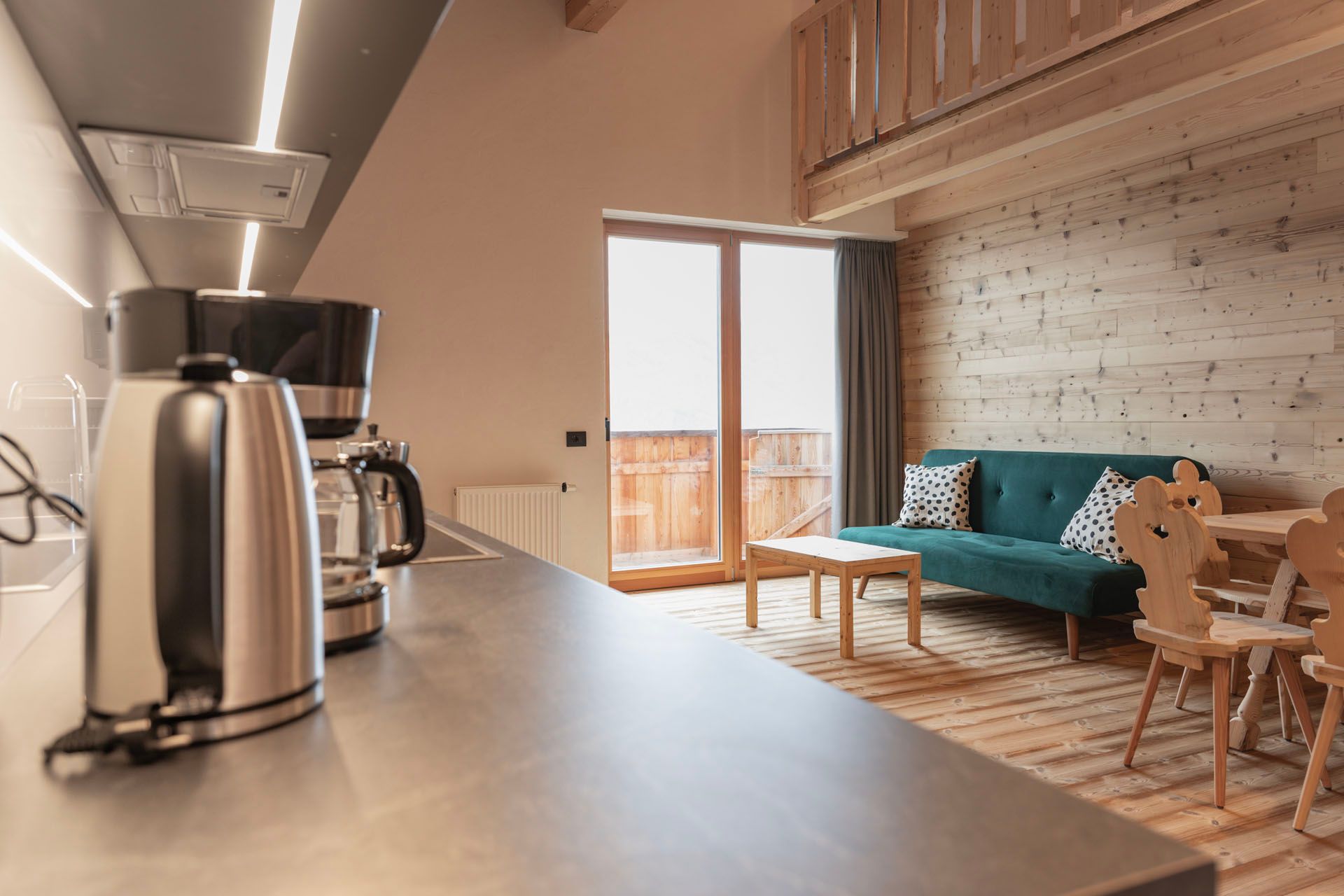 Eine Küchentheke mit Kaffeemaschine und einem Sofa im Hintergrund.