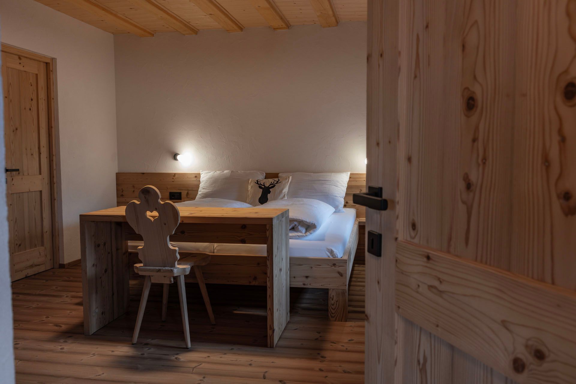 Ein Schlafzimmer mit einem Holztisch und Stühlen und einem Bett.