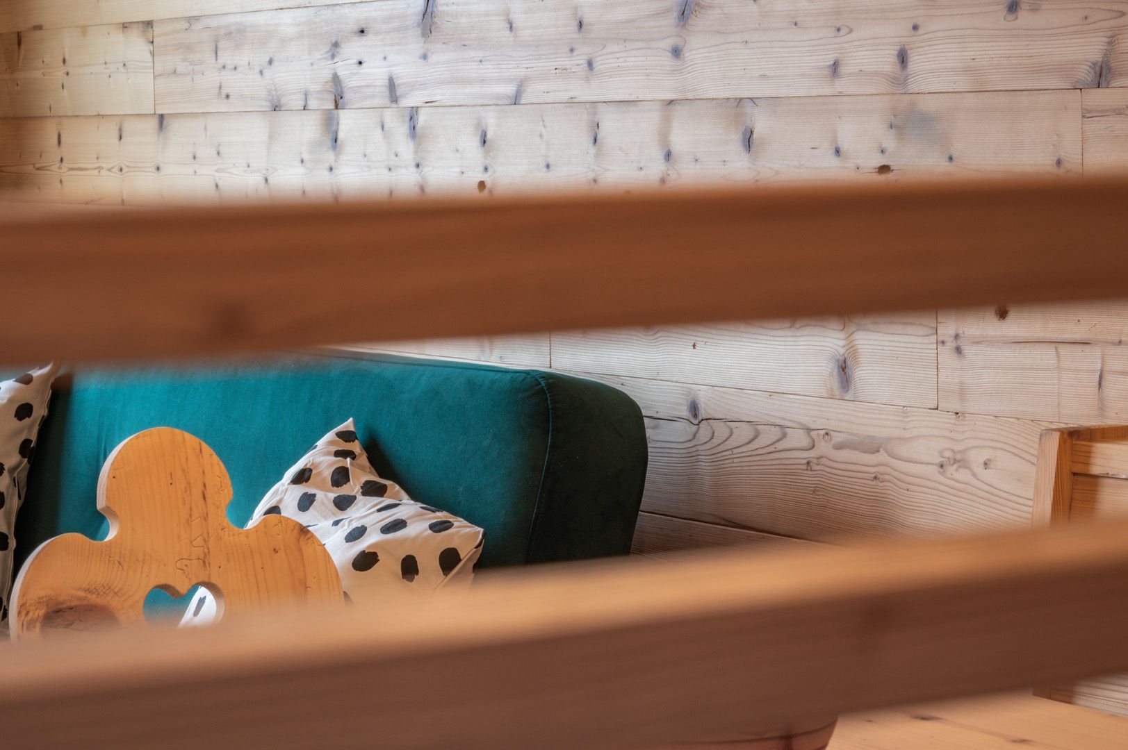In einem Raum mit einem Holzgeländer steht eine Couch mit zwei Kissen darauf.