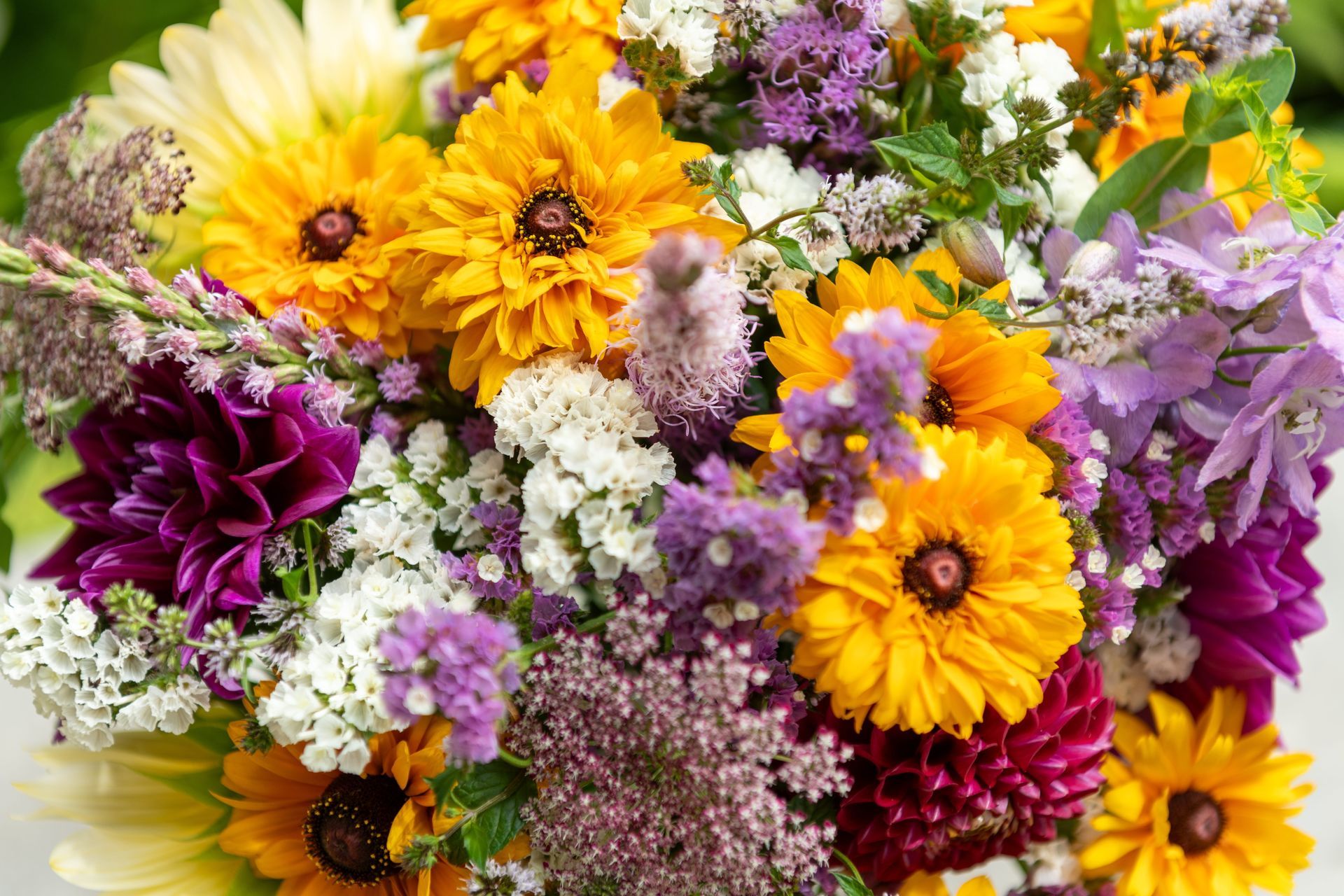 Bright mixed bouquet of yellow, purple, white, and pink flowers