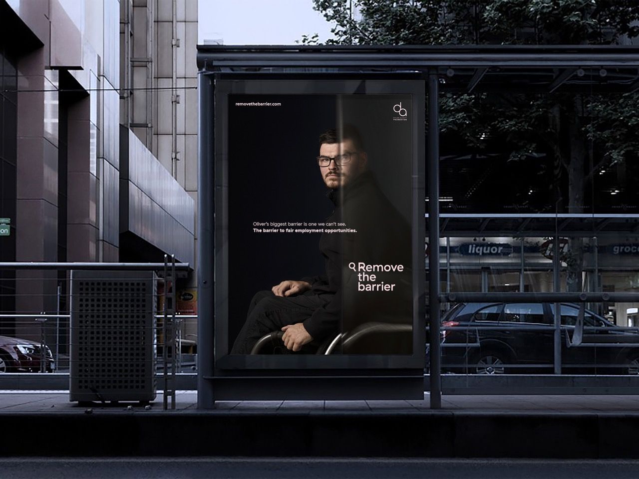 Bus stop billboard of a male wheelchair user, side profile. Half the billboard is blurred with white text that reads 
