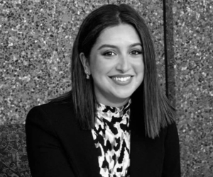 Black and white photo of a woman with brown hair wearing a blazer