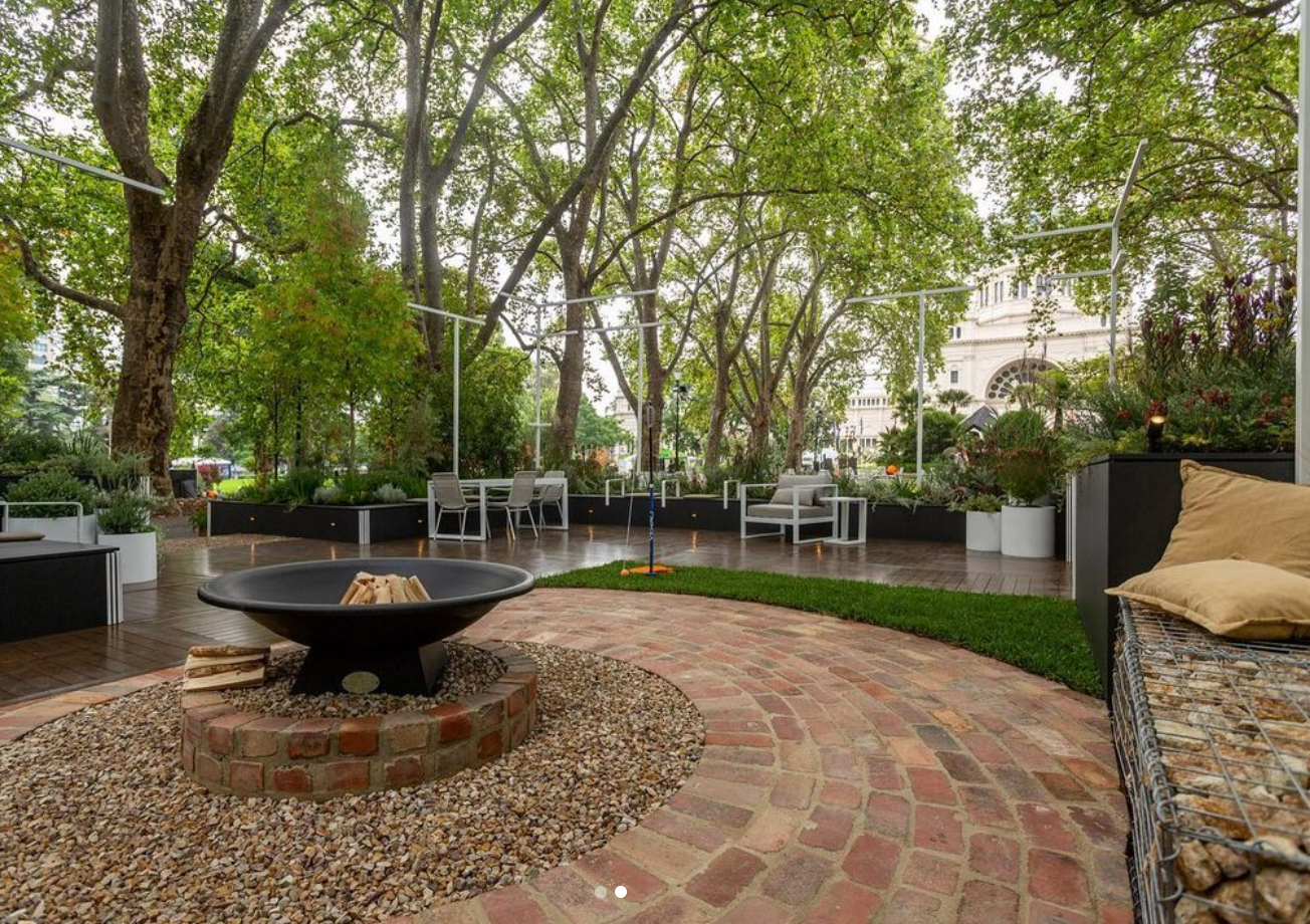 Accessible outdoor garden with paved path, fire place and seating areas. 