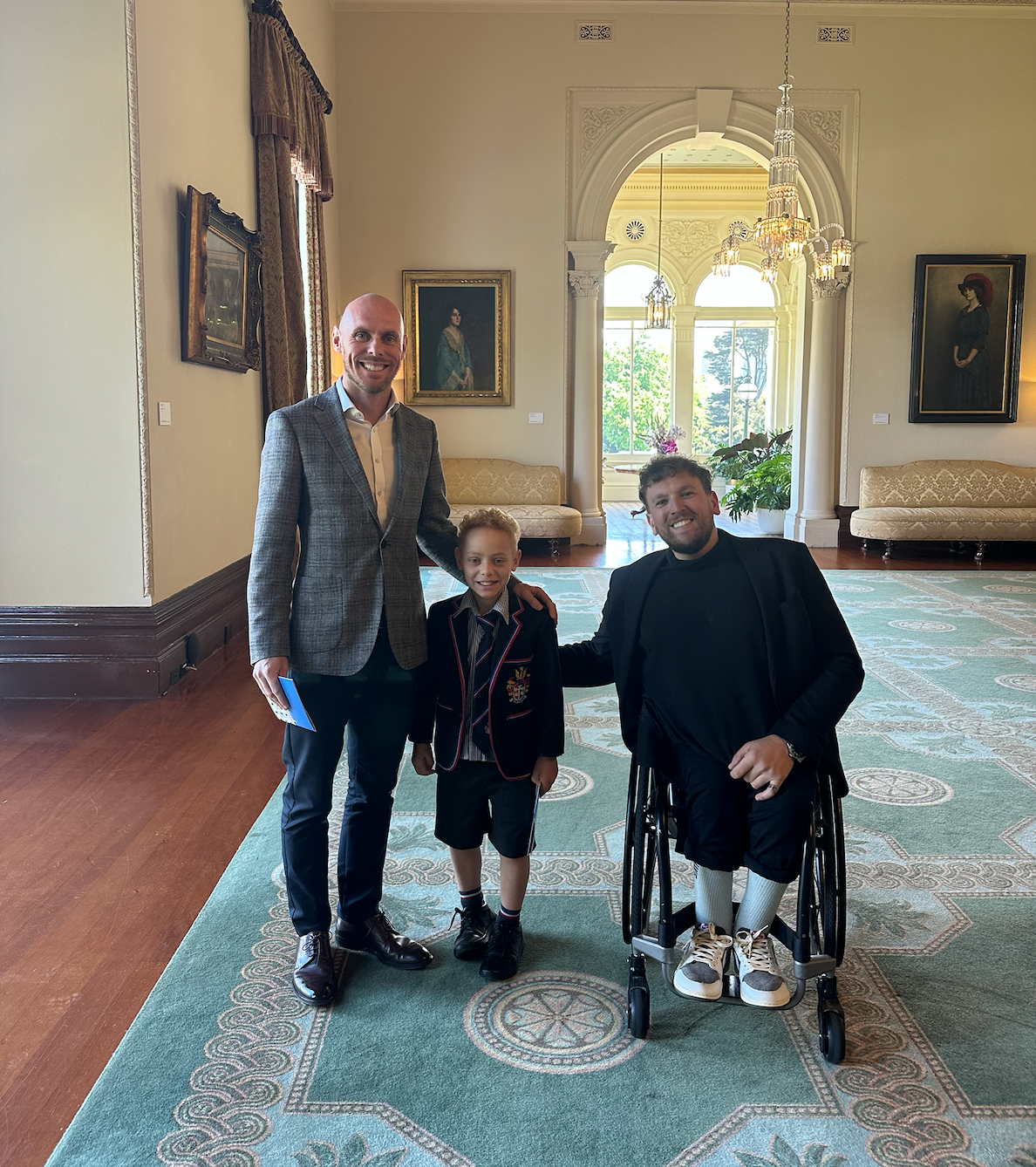 Dylan (right) with recipient Alex (middle) and his father (left) smiling to camera.